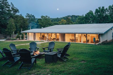 Sommer House Inn lodge glowing at dusk with Adirondack chairs around the outdoor fire pit