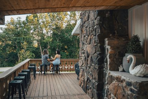 Guests sharing drinks at the bar rail on the covered front porch of Sommer House Inn, Jasper AR